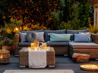 Útulná podzimní terasa s gaučem a stolečkem.